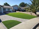 Photo of a yard with artificial turf and a hardscape walkway.