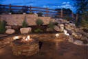 Photo of a back yard landscape with a fireplace and hardscape.