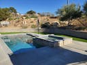 Photo of a backyard with artificial turf, a pool, and hardscape