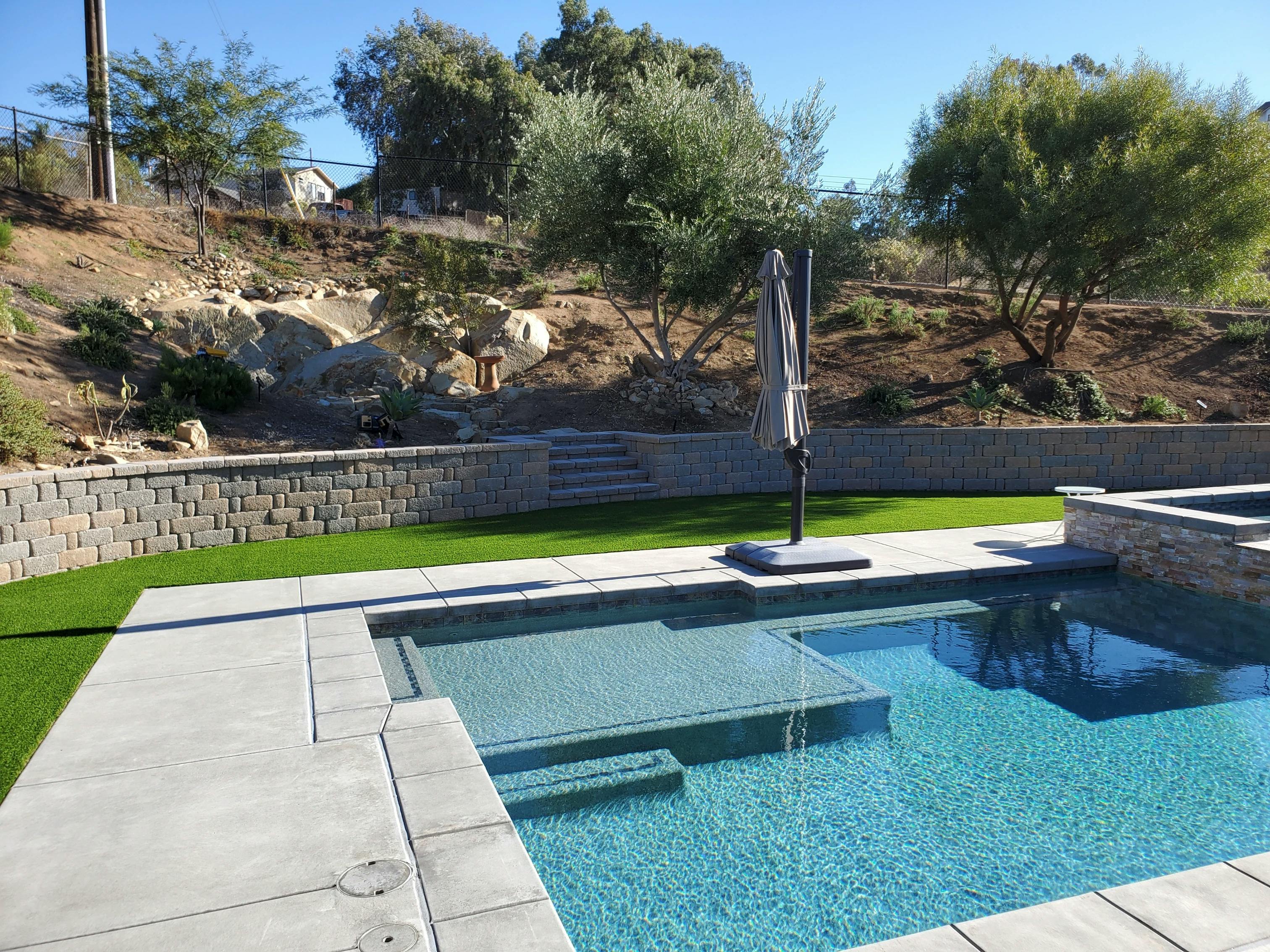 Photo of a backyard with artificial turf and a pool